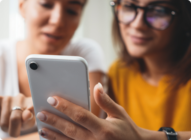 2 Frauen schauen auf ein Handy - starkes employer branding