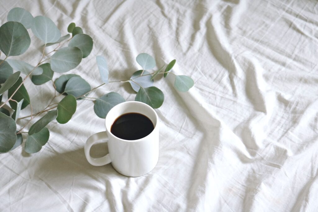 Eine Kaffee Tasse steht auf einer Matratze. Pausen sind wichtig für Mindful Working.