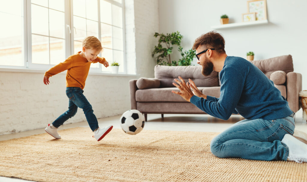 Ein Vater spielt mit seinem Sohn Fußball, was beim Gewichtsverlust helfen kann